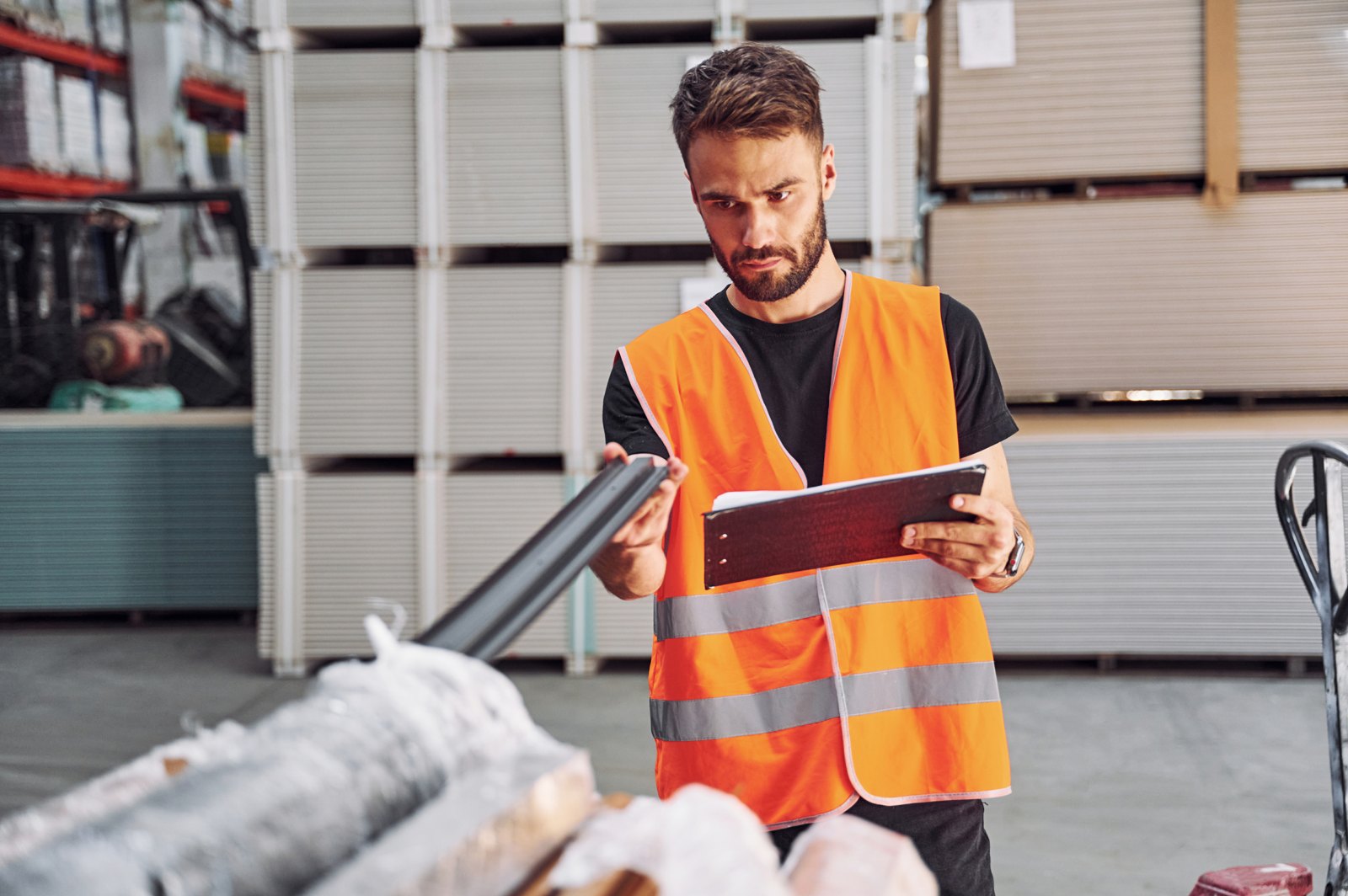 Warehouse worker inspecting materials with a clipboard