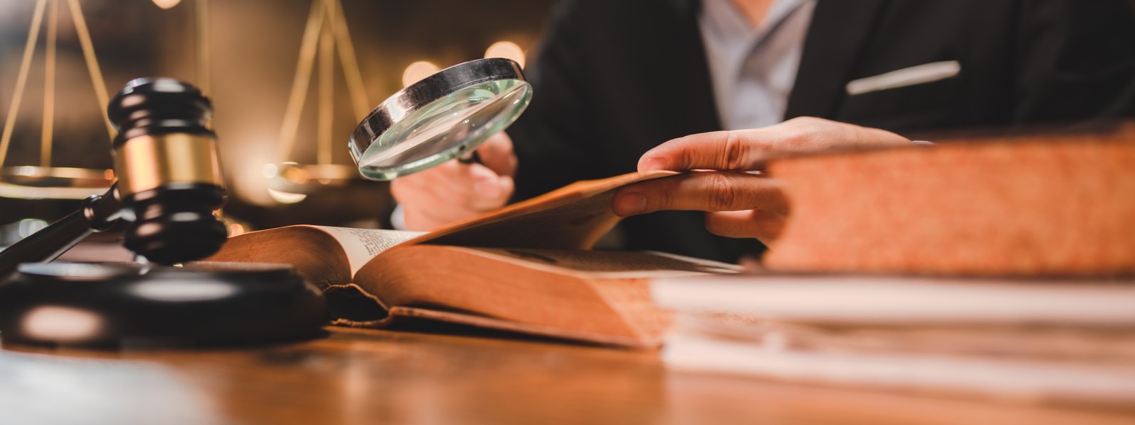 Legal professional examining documents with a magnifying glass